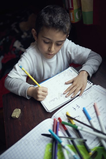 Hispanic boy practicing writing alphabet