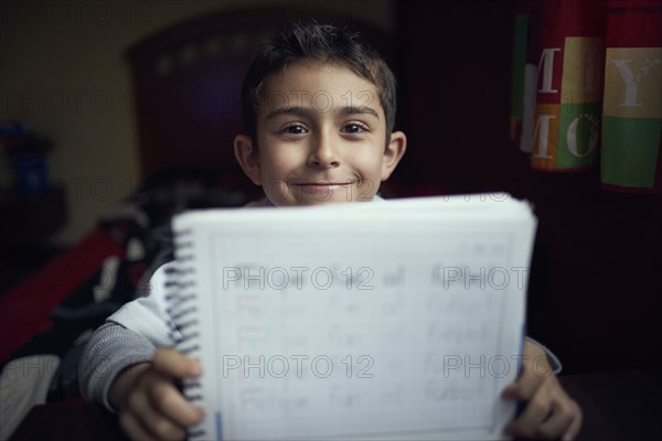 Proud Hispanic boy practicing writing alphabet