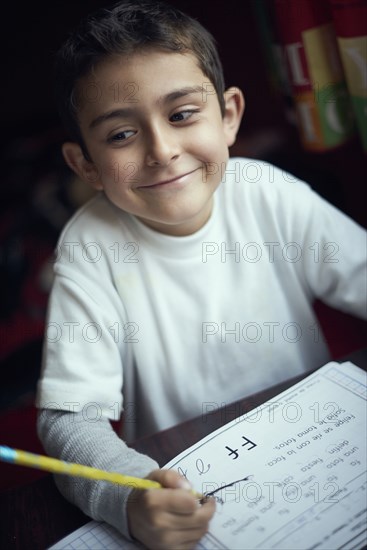 Proud Hispanic boy practicing writing alphabet