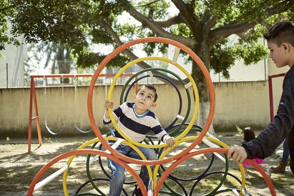 Hispanic boys climbing on structure at playground