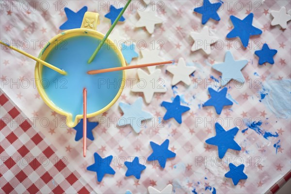 Paintbrushes and blue stars on table