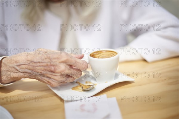 Hand of older Caucasian woman drinking coffee