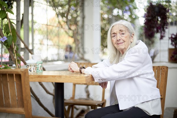 Portrait of smiling older Caucasian woman sitting at table