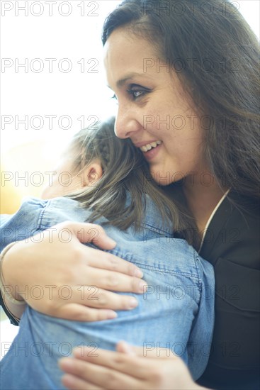 Hispanic mother hugging daughter