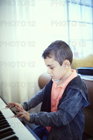 Hispanic boy playing piano