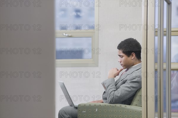 Mixed race businessman working on laptop in office