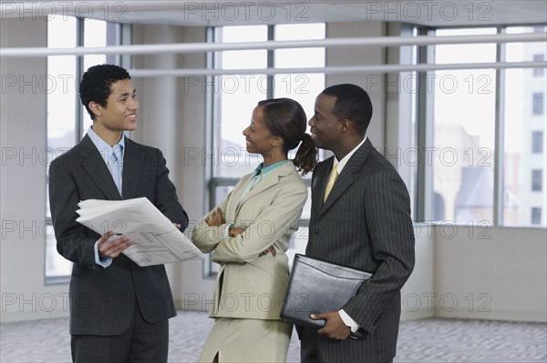 Multi-ethnic business people reviewing blueprints