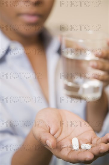 Close up of African woman holding pills