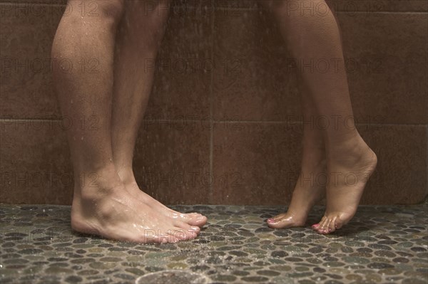 Multi-ethnic couple's legs in shower