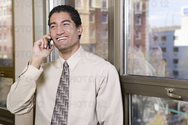 Mixed race businessman talking on cell phone