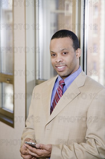 African businessman holding cell phone
