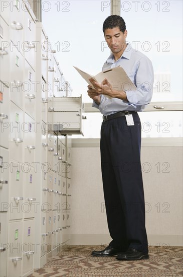 Mixed race businessman looking at files