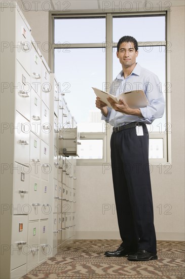 Mixed race businessman looking at files