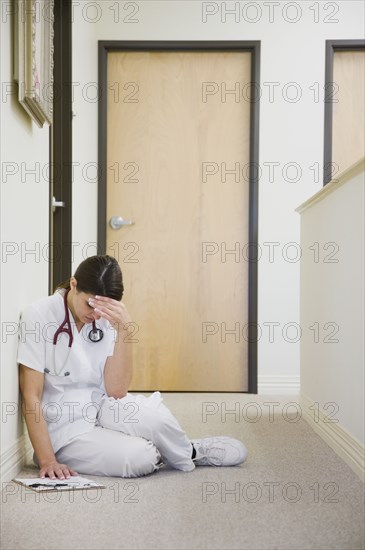 Nurse sitting on floor feeling ill