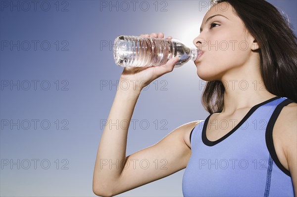 Thirsty Hispanic woman drinking water