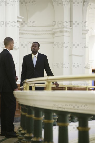 African businessmen talking near railing