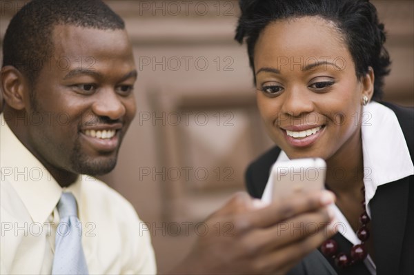 African business people looking at cell phone