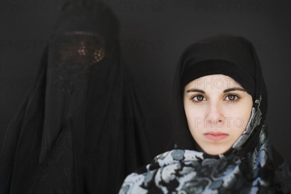 Middle Eastern woman in burka and teenager in headscarf