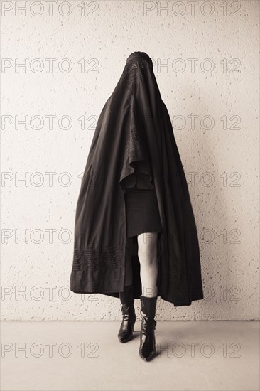 Middle Eastern woman in burka and high heeled boots