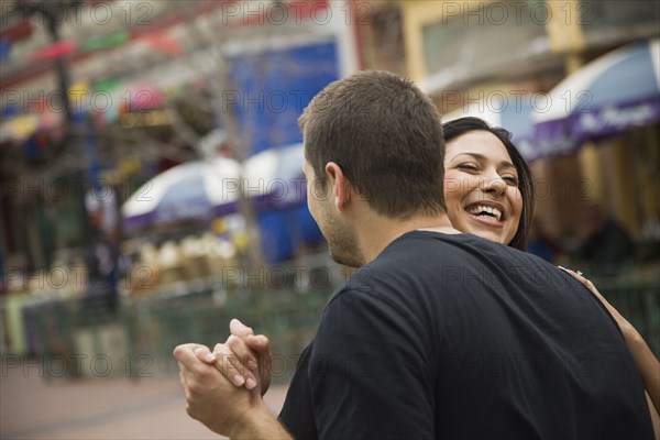 Laughing couple dancing outdoors