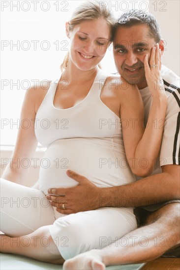 Man hugging pregnant woman's stomach