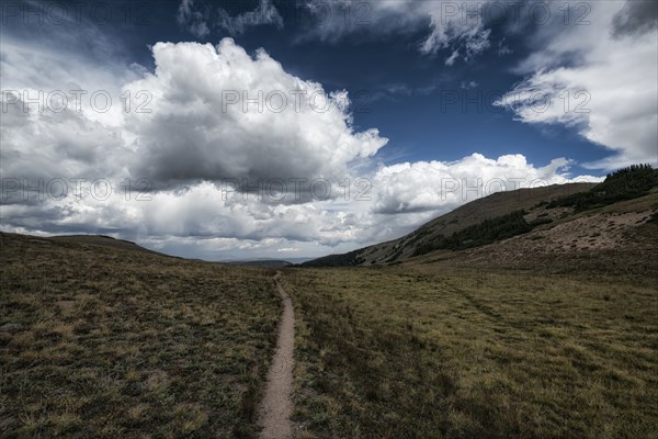 Clouds over trail in rolling landscape