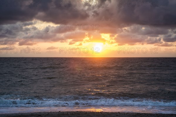 Ocean waves on beach at sunset