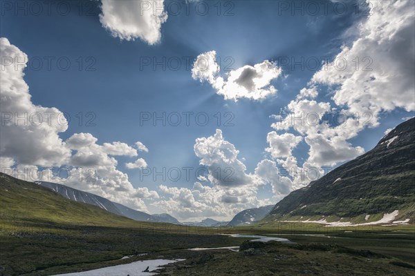 Sunbeams over river in remote valley