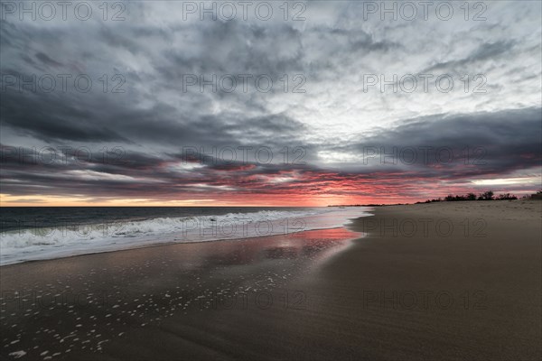 Ocean waves on beach at sunset