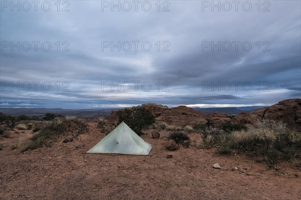 Camping tent in landscape under clouds