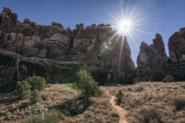 Sun in blue sky over desert path