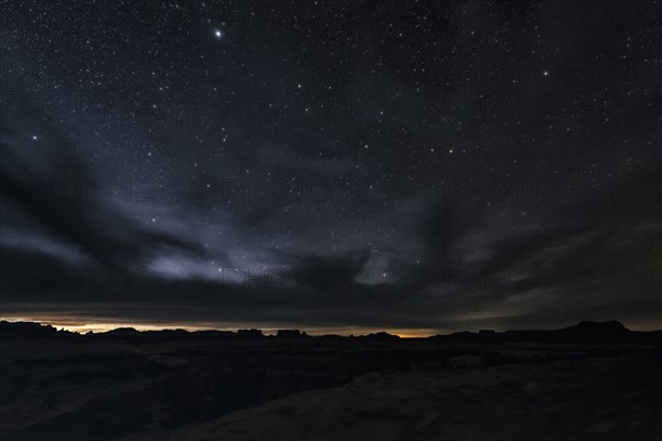 Clouds and stars in sky over desert