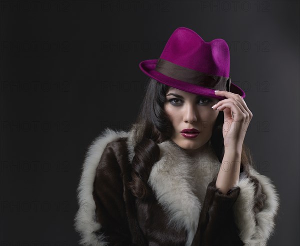 Mixed Race woman wearing hat and fur coat