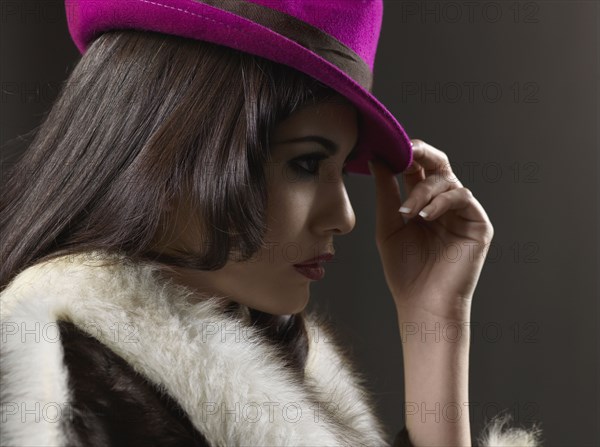 Mixed Race woman wearing hat and fur coat