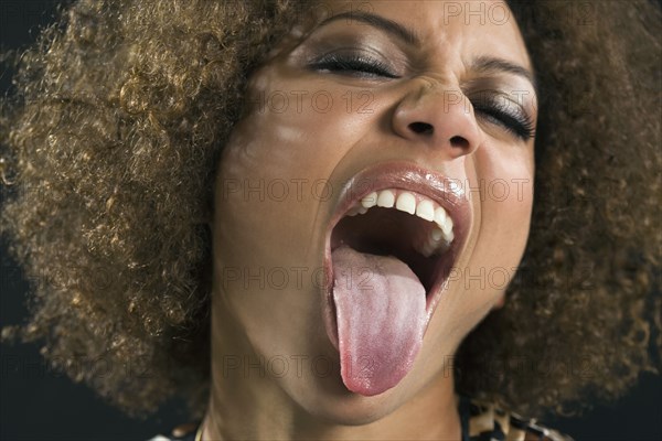 Mixed Race woman sticking out tongue