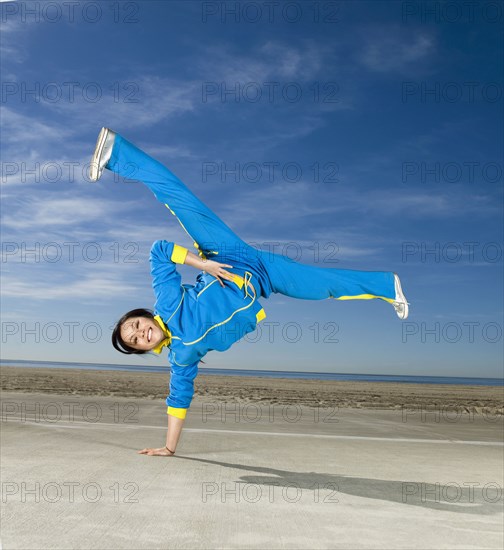 Asian woman balancing on one hand