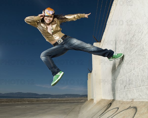 Asian woman jumping off wall