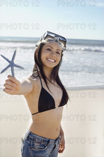Asian woman holding starfish