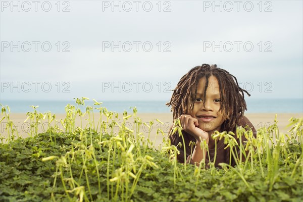 Mixed Race boy laying in plants