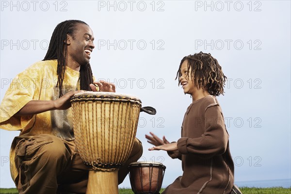 African father and son playing drums