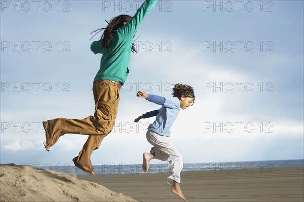 African brothers jumping on sand dune