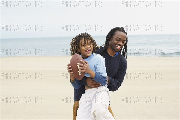 African father an son playing football