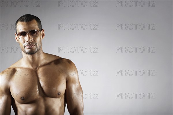 Bare chested mixed race man in sunglasses