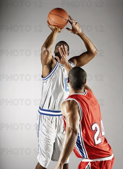 Basketball player trying to take basketball from opponent