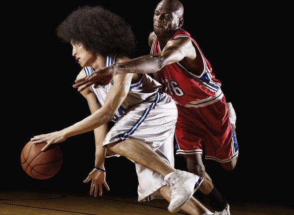 Basketball player trying to take basketball from opponent