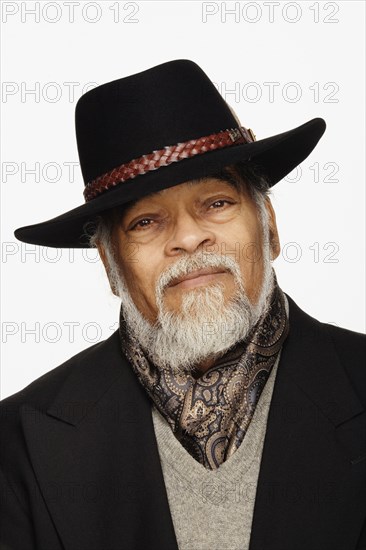 Close up studio shot of senior African man wearing hat