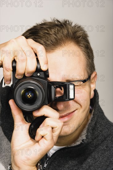 Close up studio shot of man using camera