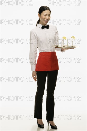 Studio shot of Asian waitress holding tray of drinks