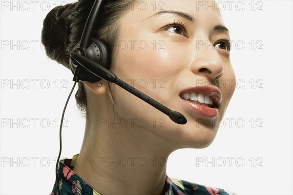 Studio shot of Asian woman wearing headset