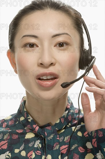 Studio shot of Asian woman wearing headset